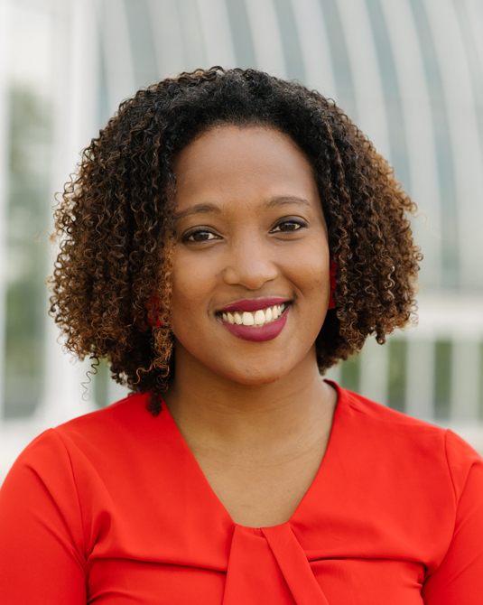 Afro latina woman in red shirt smiling